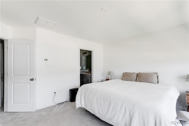 bedroom featuring light colored carpet, baseboards, visible vents, and ensuite bath