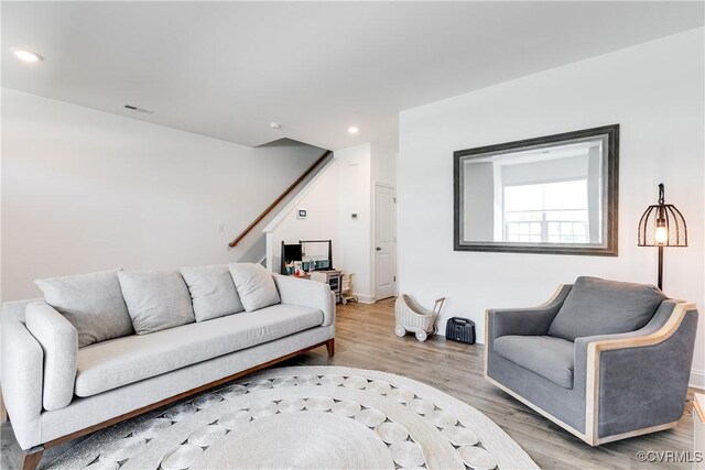 living area featuring visible vents, stairs, wood finished floors, baseboards, and recessed lighting