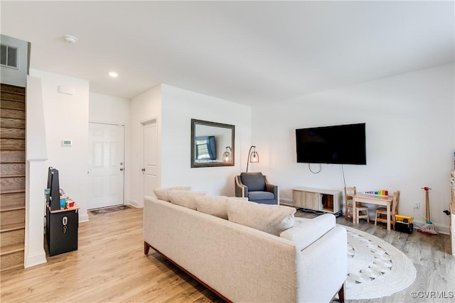 living room with visible vents, stairs, light wood-style floors, baseboards, and recessed lighting