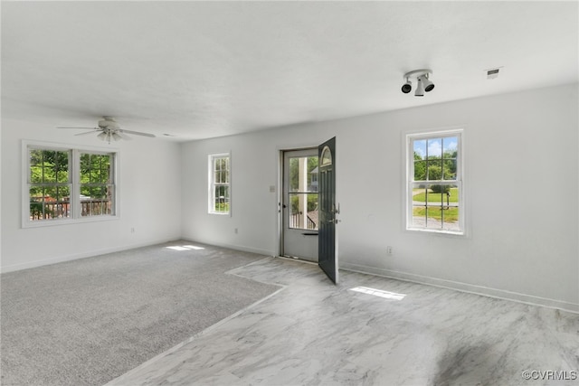 unfurnished room featuring healthy amount of natural light and baseboards