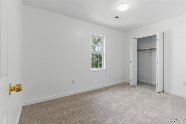 unfurnished bedroom with light colored carpet, baseboards, and a closet