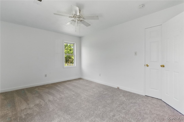 carpeted spare room featuring a ceiling fan, baseboards, and a smoke detector