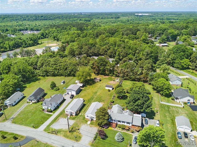 view of property location featuring a forest and nearby suburban area