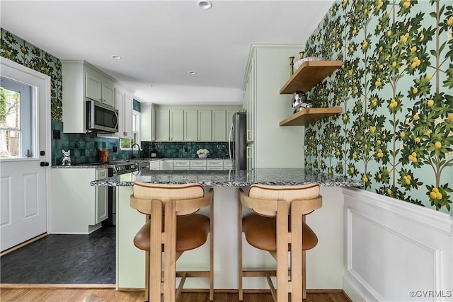3454 Warner Rd, Richmond, VA 23225 - kitchen with appliances with stainless steel finishes, a peninsula, open shelves, backsplash, and dark stone countertops