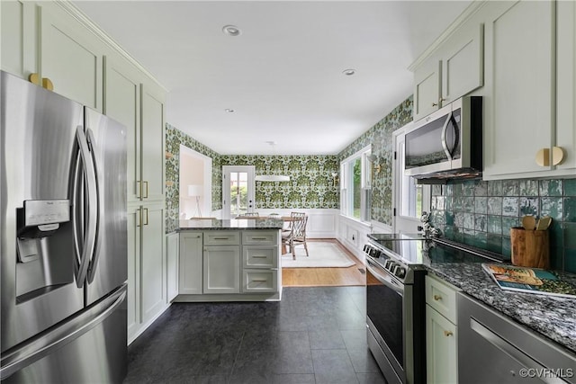 3454 Warner Rd, Richmond, VA 23225 - kitchen featuring stainless steel appliances, wallpapered walls, a peninsula, dark stone counters, and wainscoting