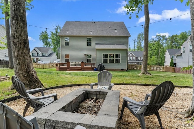 rear view of house featuring a lawn, an outdoor fire pit, and fence