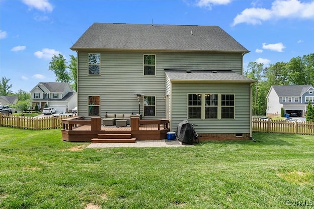 rear view of property with a lawn, a deck, and fence