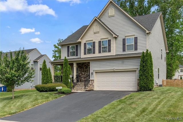 traditional-style house with fence, an attached garage, a front lawn, and aphalt driveway