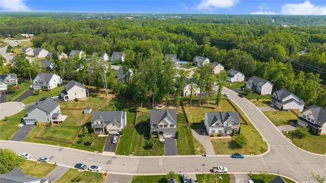 drone / aerial view featuring a residential view and a view of trees
