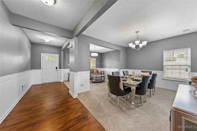 dining space with a chandelier, wainscoting, wood finished floors, and visible vents