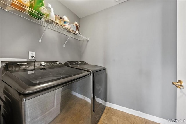clothes washing area featuring laundry area, washer and clothes dryer, and baseboards