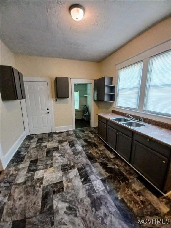 130 Elm St, Petersburg, VA 23803 - kitchen featuring a sink, baseboards, a textured ceiling, and open shelves