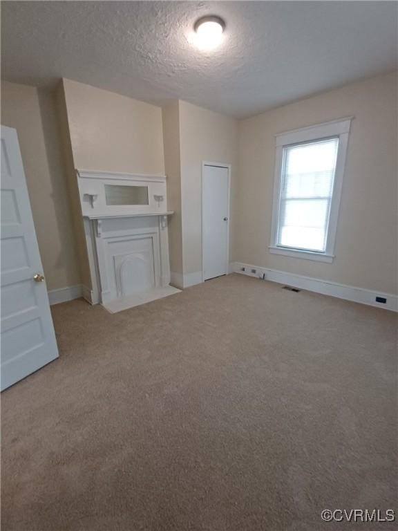 130 Elm St, Petersburg, VA 23803 - unfurnished living room with a textured ceiling, light colored carpet, and baseboards