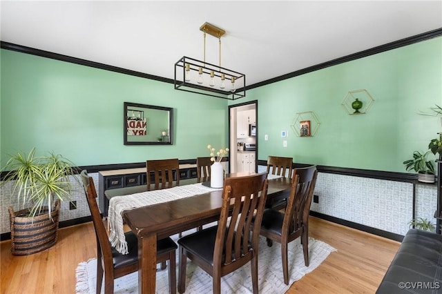 dining area with crown molding, baseboards, and wood finished floors