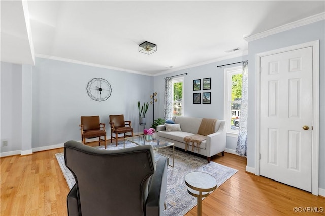 living room with visible vents, ornamental molding, light wood finished floors, and baseboards