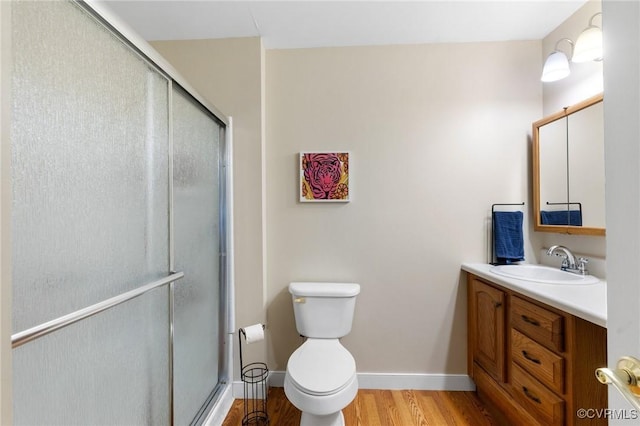 full bathroom featuring vanity, a shower stall, toilet, and wood finished floors