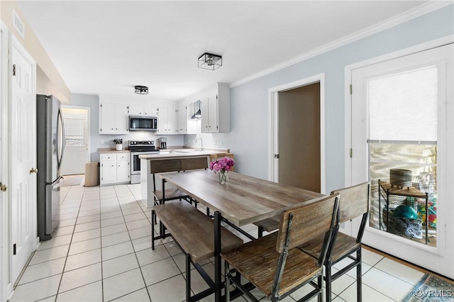 dining room featuring crown molding, visible vents, and light tile patterned floors