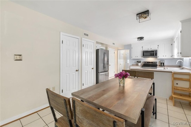 dining room featuring baseboards, visible vents, and light tile patterned floors