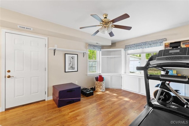 workout room with ceiling fan, wood finished floors, and visible vents