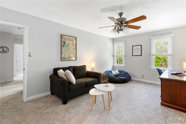 living room featuring a ceiling fan, baseboards, and light colored carpet