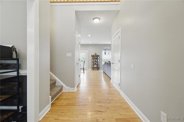 corridor featuring stairs, recessed lighting, baseboards, and light wood-style floors