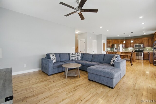 living area featuring recessed lighting, a ceiling fan, and light wood-style flooring