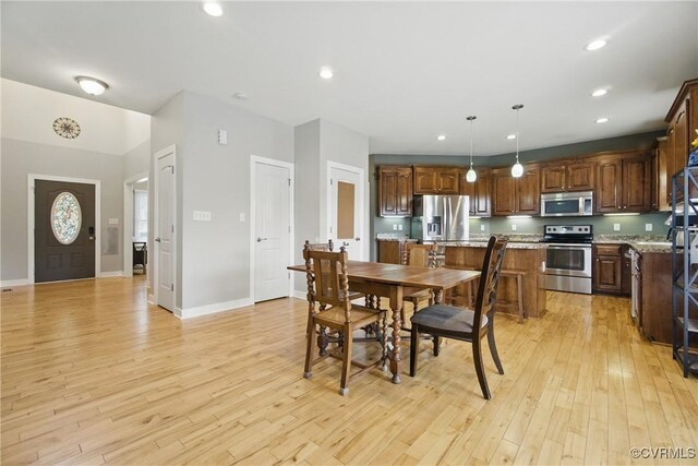dining room featuring baseboards, recessed lighting, and light wood-style flooring