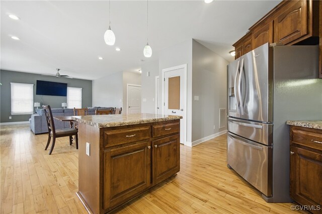 kitchen featuring light wood-style floors, baseboards, ceiling fan, and stainless steel fridge with ice dispenser