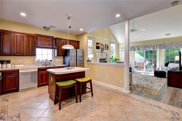 kitchen with stainless steel appliances, open floor plan, a sink, and a center island