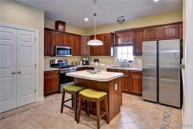 kitchen with a center island, a sink, light countertops, light tile patterned floors, and stainless steel appliances