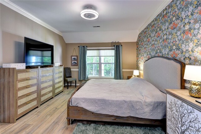 bedroom featuring ornamental molding, wallpapered walls, light wood-style flooring, and visible vents
