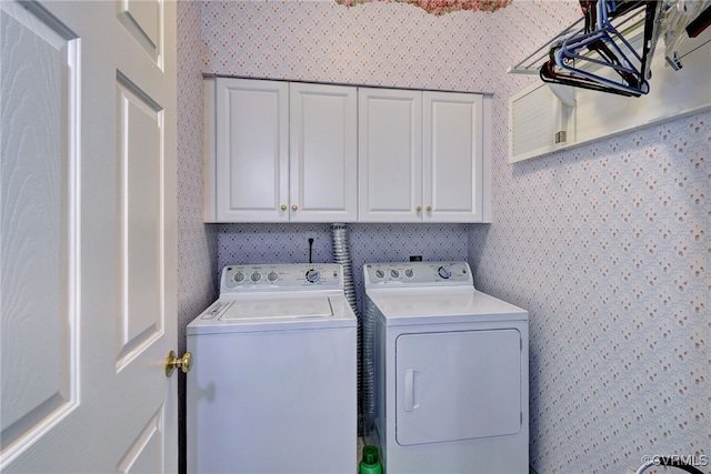 laundry room featuring cabinet space, washing machine and clothes dryer, and wallpapered walls