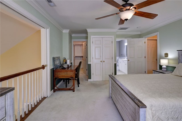bedroom featuring visible vents, ornamental molding, ensuite bathroom, and light colored carpet