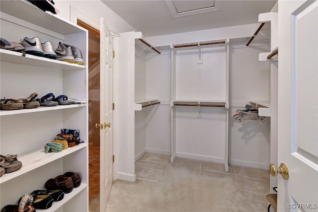walk in closet featuring light carpet