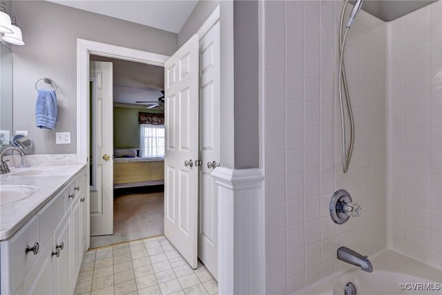 bathroom with ceiling fan, a sink, ensuite bath, double vanity, and shower / bathtub combination
