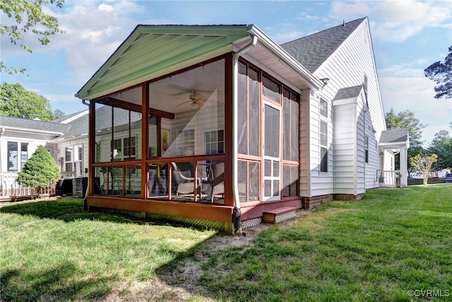 back of property with a yard and a sunroom