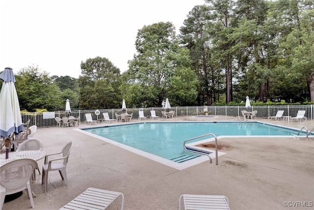 pool with a patio area and fence