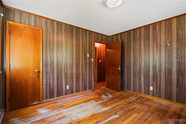 unfurnished room with wooden walls and wood finished floors