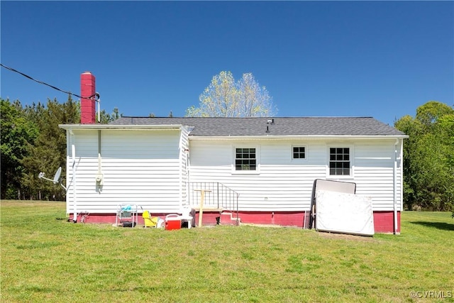 rear view of house with a lawn and a chimney