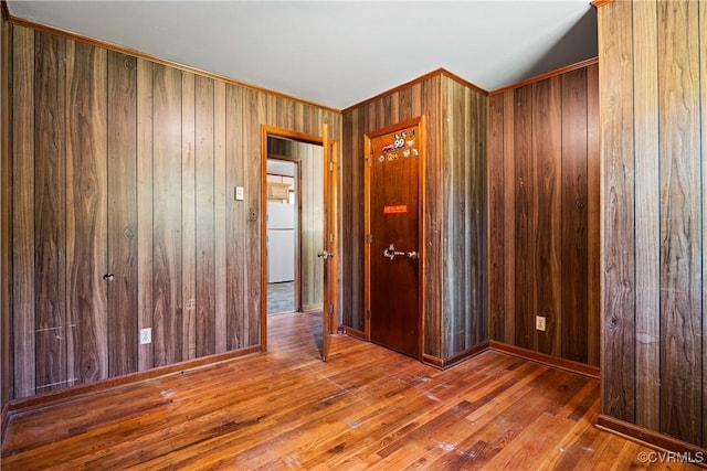 unfurnished room featuring wood walls and wood finished floors