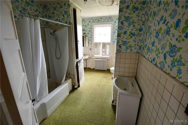 full bathroom with wainscoting, toilet, radiator, wallpapered walls, and tile walls