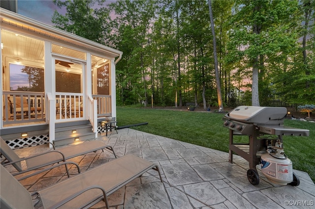 view of patio featuring a sunroom, area for grilling, and view of wooded area