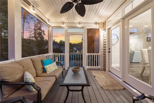 sunroom featuring track lighting, a ceiling fan, and an outdoor living space