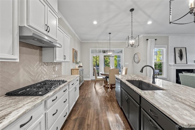 kitchen featuring a sink, under cabinet range hood, stainless steel appliances, french doors, and white cabinetry