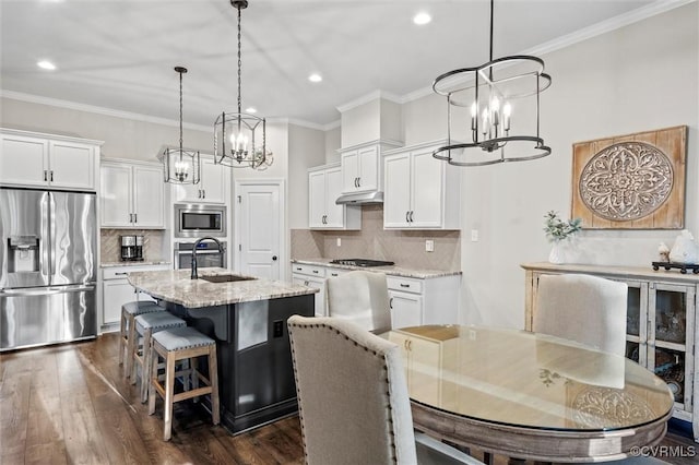 kitchen with stainless steel appliances, a chandelier, a sink, white cabinets, and ornamental molding