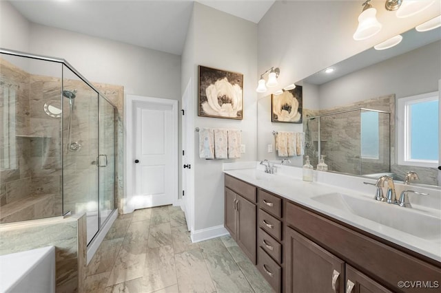 full bathroom featuring marble look tile flooring, a shower stall, double vanity, and baseboards