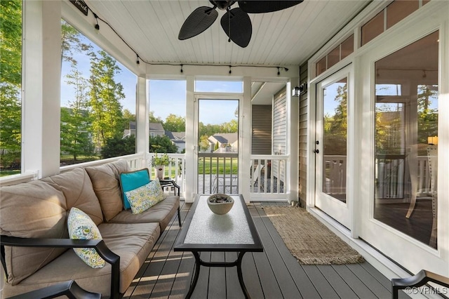 sunroom / solarium featuring rail lighting and a ceiling fan
