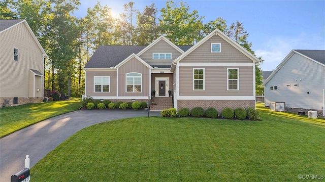 craftsman-style home with driveway and a front yard
