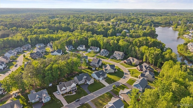 aerial view of property's location featuring a forest, a nearby body of water, and nearby suburban area