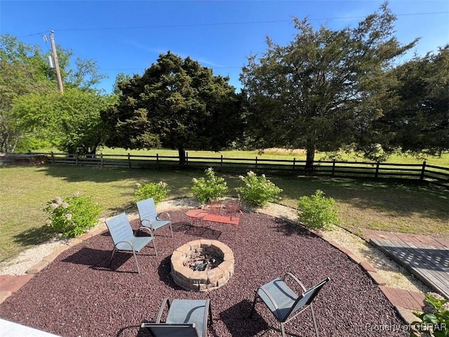 view of yard featuring a fire pit, a fenced backyard, and a patio area